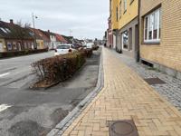 Et eksempel på en cykelsti som er alt for smal og har et meget snoet forløb. Det er en udfordring at køre med ladcykel eller cykelanhænger. Der er desuden en høj stålkant, som kan være ubehagelig at ramme. Hele forløbet fra Rema til lyskrydeset ved Gammel Banegårdsvej er smalt, svingende og zigzag mellem parkerede biler.